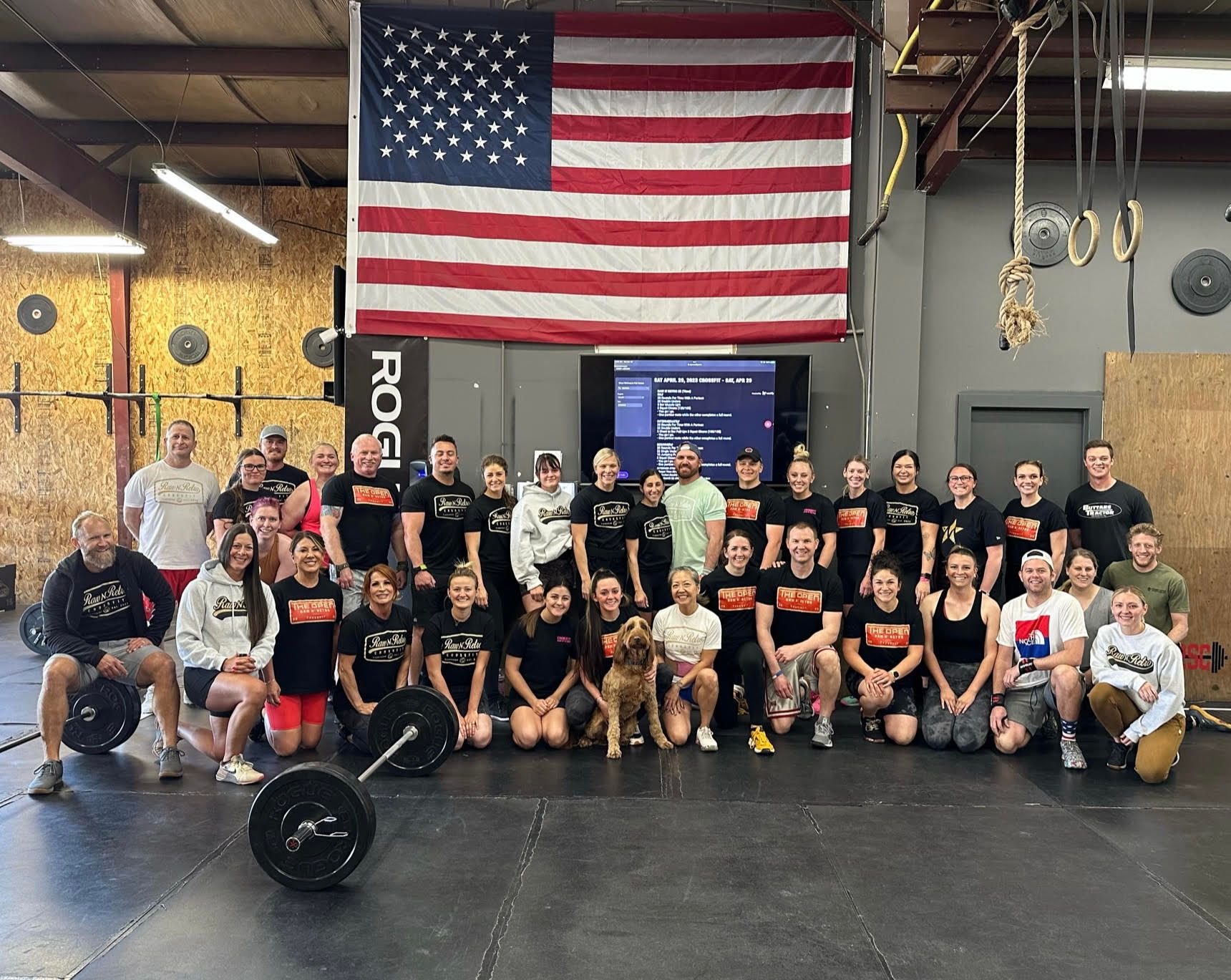 A group of people are posing for a picture in front of an american flag.
