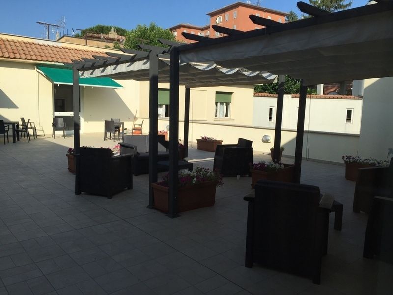 un patio con sedie e tavoli sotto un pergolato