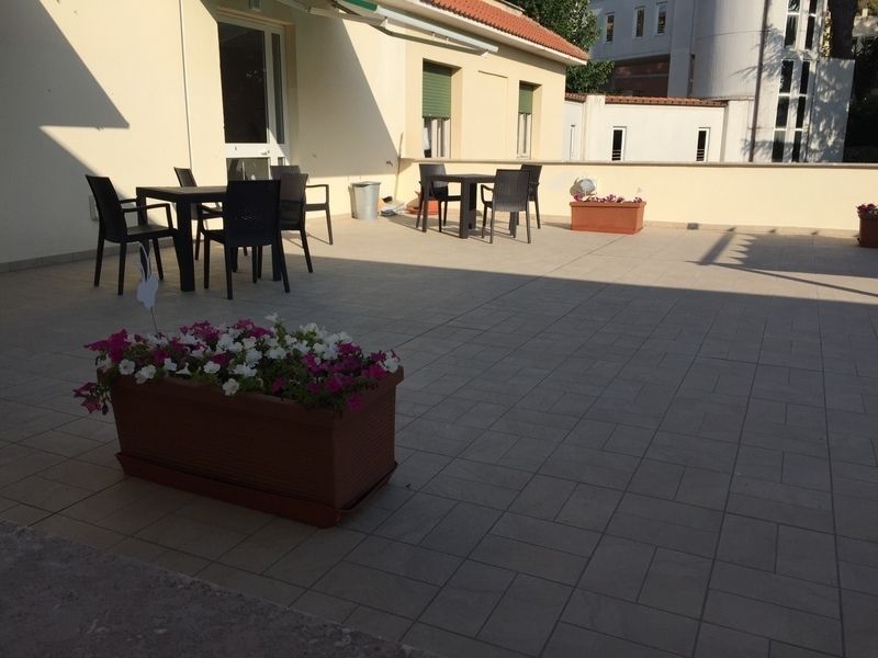 un patio con tavoli e sedie e un vaso di fiori