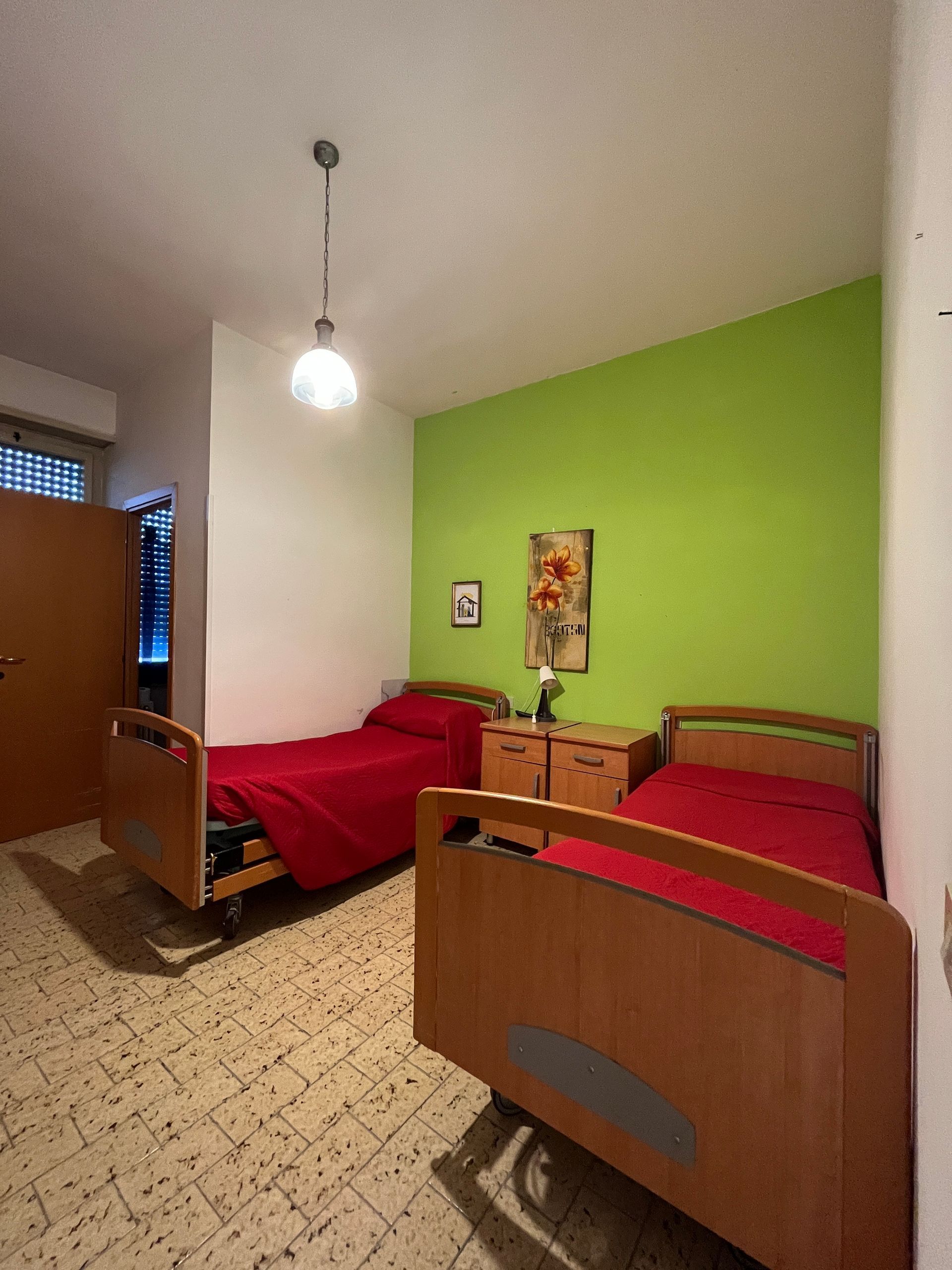 camera da letto con due letti e una parete verde .