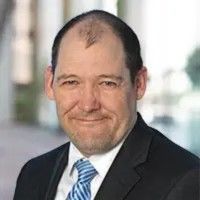 A man in a suit and tie is smiling for the camera.