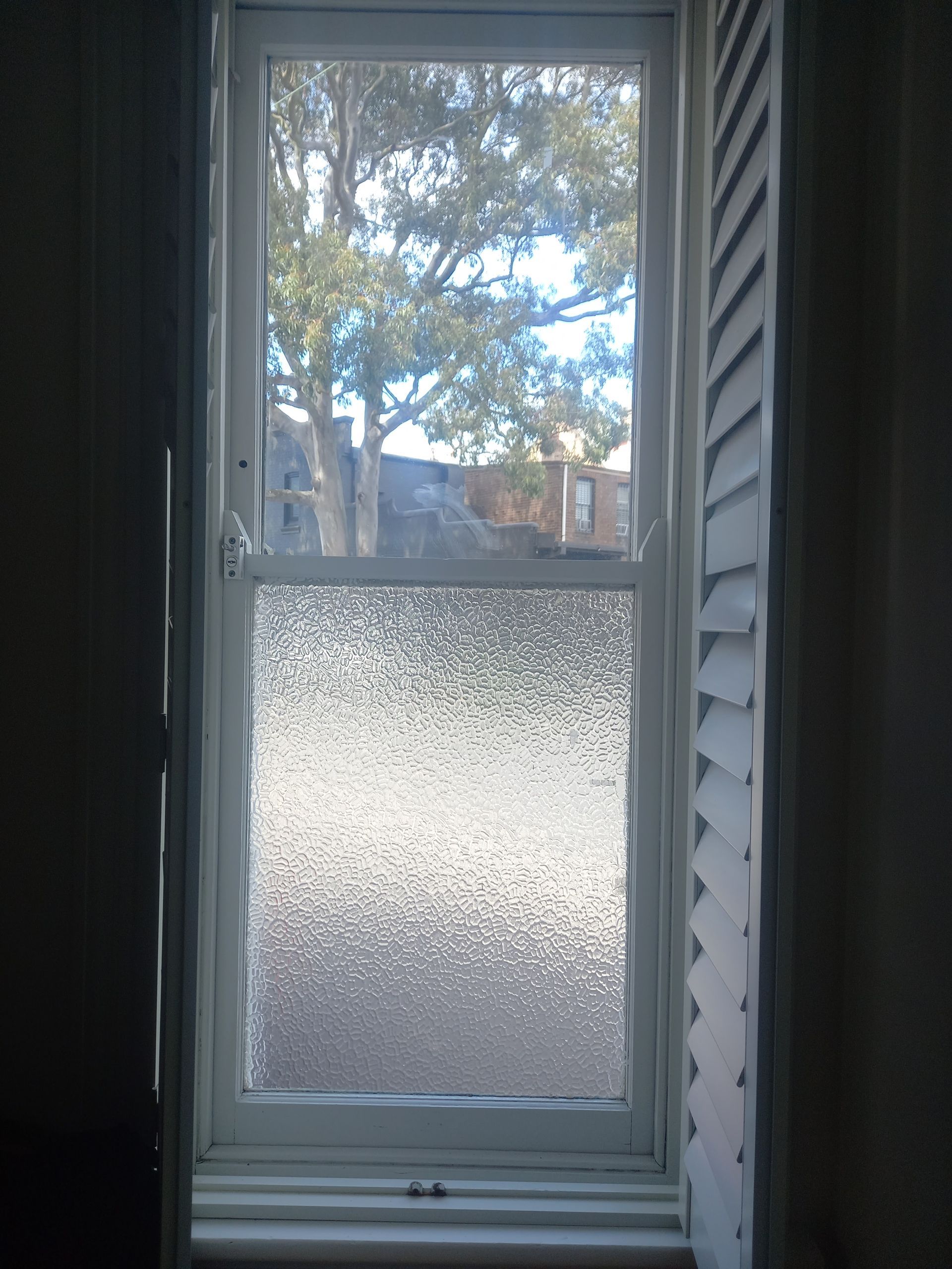 A window with a stained glass window and shutters