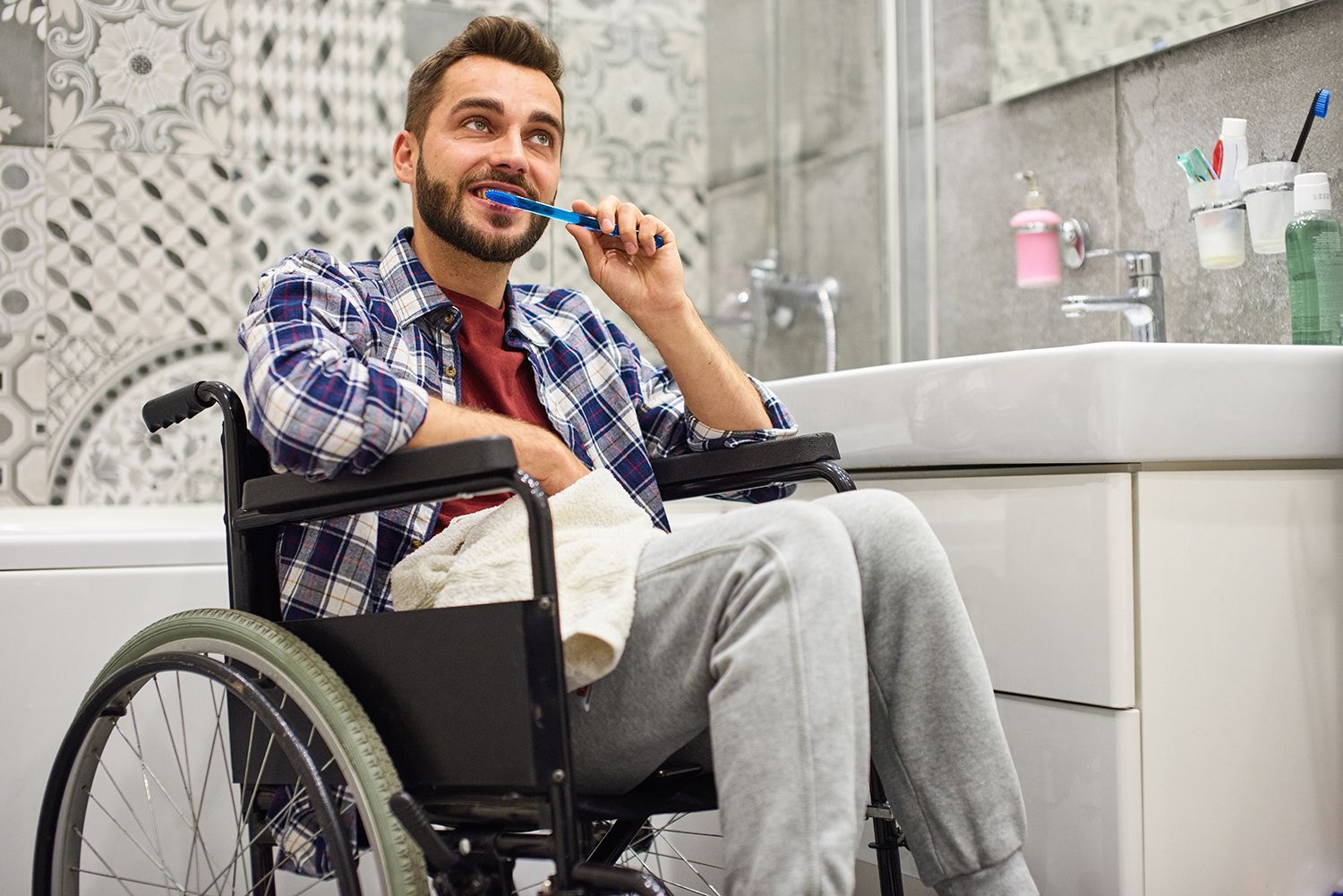 man on a wheelchair brushing his teeth