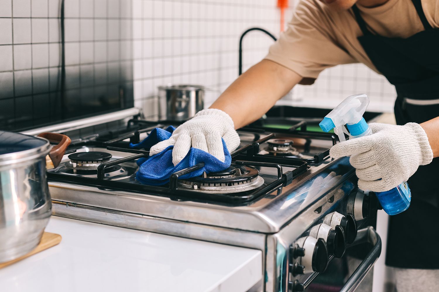 a person cleaning the stovetop