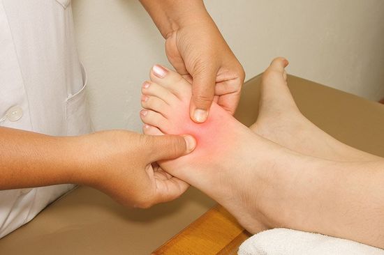 Podologo massaggia il piede di una paziente