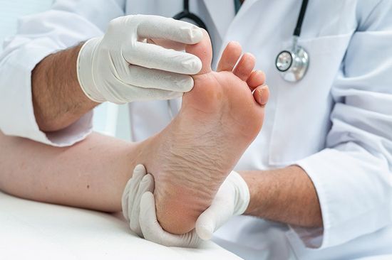 Podologo esamina le dita dei piedi di un paziente
