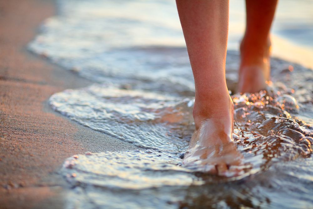 A Person is Walking on the Beach Barefoot in the Water — Psychology Practice In Tweed Heads, NSW