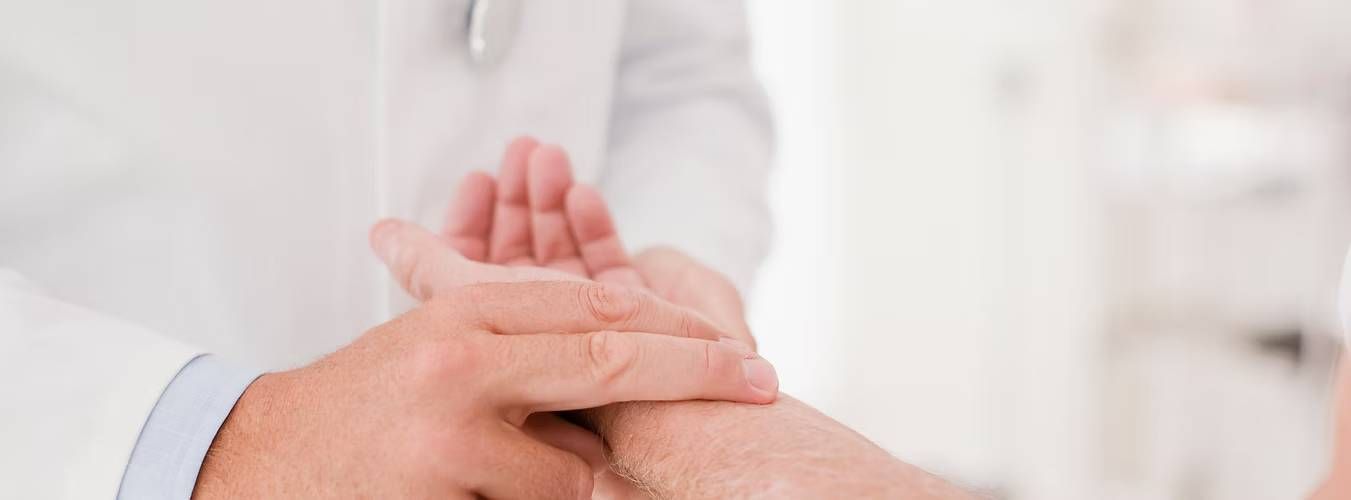 A doctor checks a patient's pulse by gently pressing two fingers on the wrist
