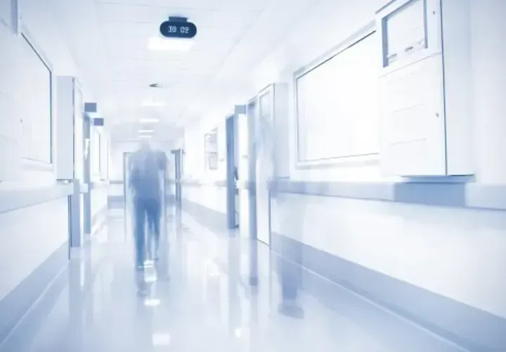 A doctor and patient sit across a desk in discussion
