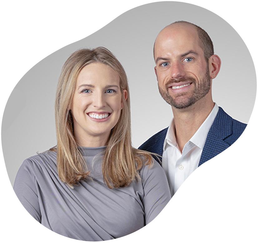 Two smiling professionals posed against a light gray background