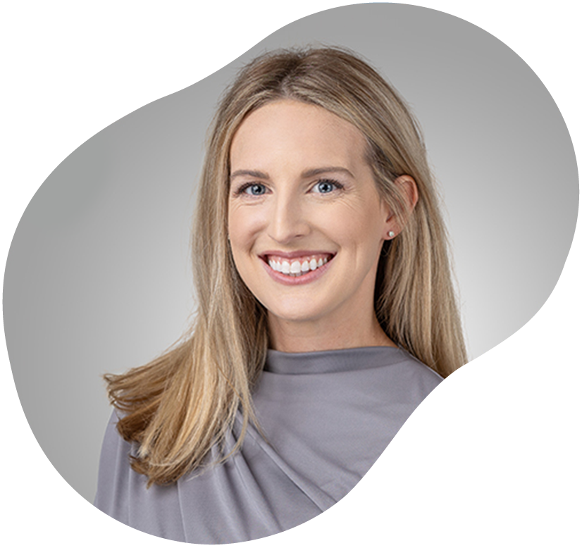 Smiling woman with blonde hair in a gray top on a light gray background