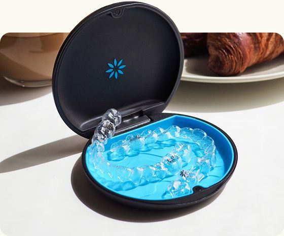 Open black jewelry case with bright blue gel and clear crystals on a white surface
