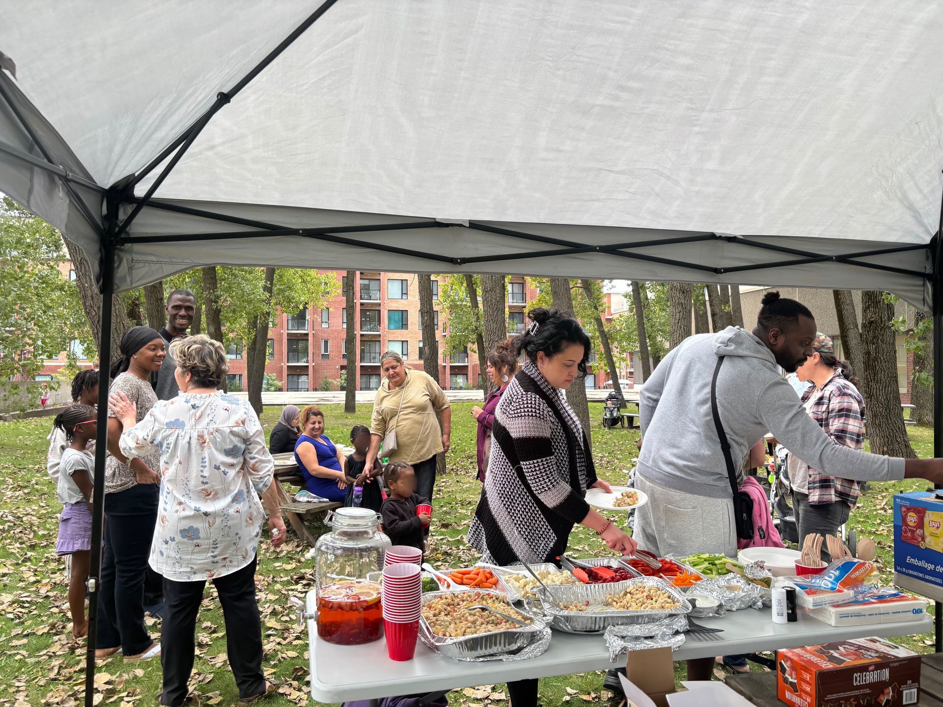 Un groupe de personnes se tient autour d'une table sous une tente.