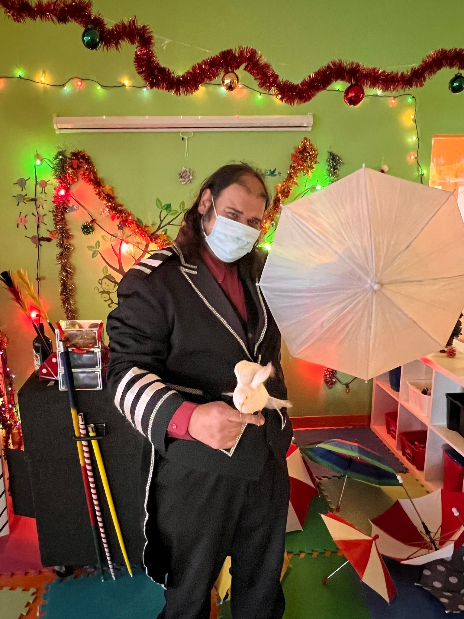 Un homme portant un masque tient un parapluie dans une pièce.