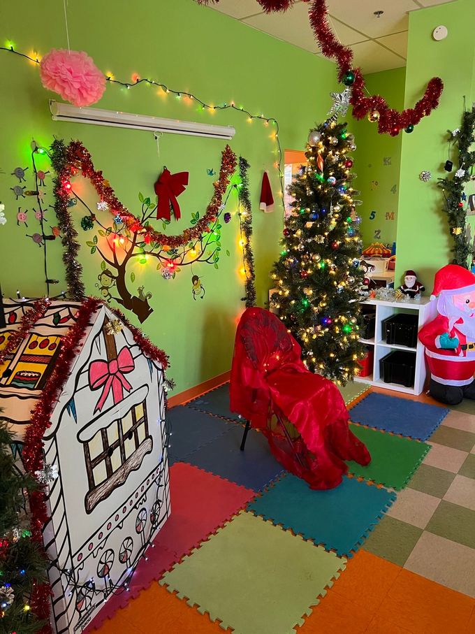 Une pièce décorée pour Noël avec une maison en pain d'épices et un sapin de Noël.