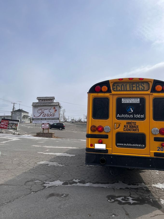 Un autobus scolaire jaune est garé sur un parking.