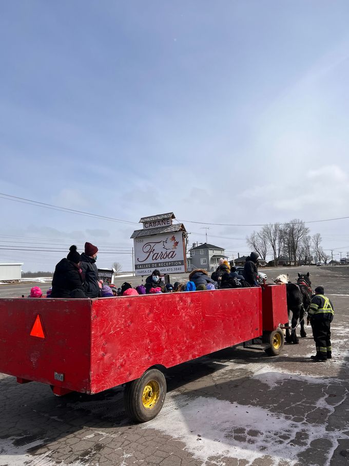 Un groupe de personnes roule dans un chariot rouge.