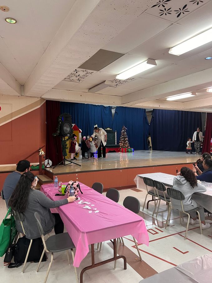 Un groupe de personnes sont assises à des tables devant une scène.