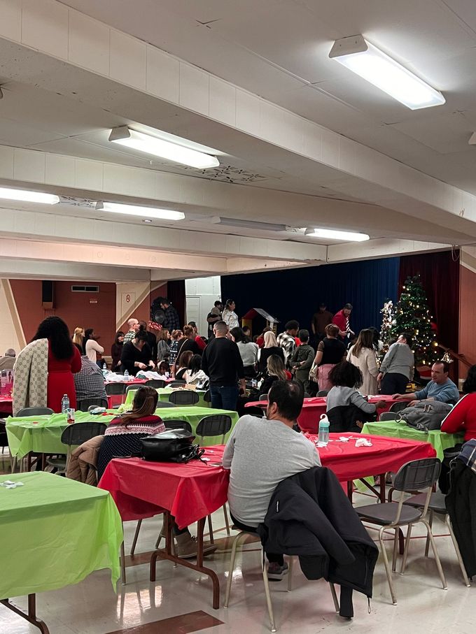 Un groupe de personnes sont assises à des tables dans une grande pièce.