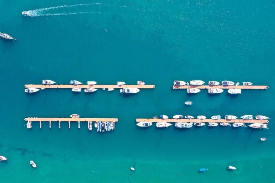 Aerial view of docks with boats in turquoise water.