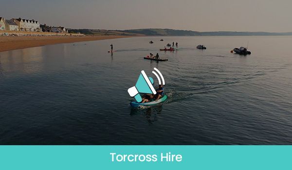 People paddleboarding on calm water, Torcross beach in the background, text overlay: