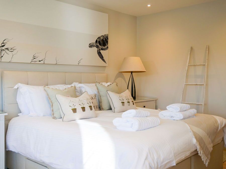 Bedroom with a large bed, decorative pillows, and a painting of a turtle above the headboard.