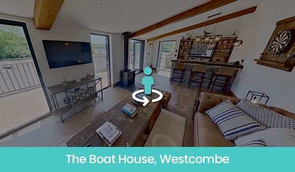 Interior view of The Boat House in Westcombe, featuring living area, bar, and outdoor access.