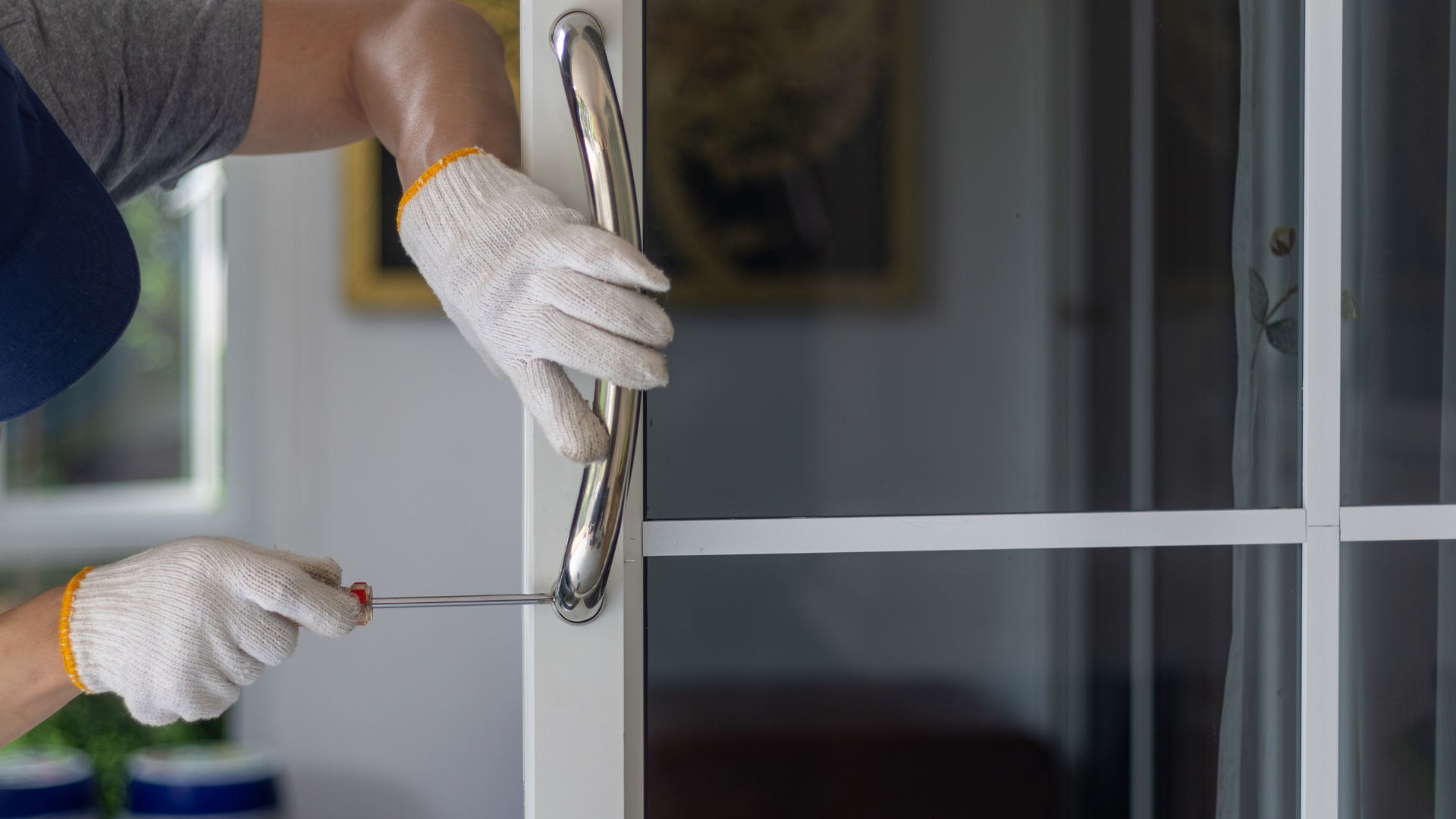 A man is fixing a door handle with a screwdriver.