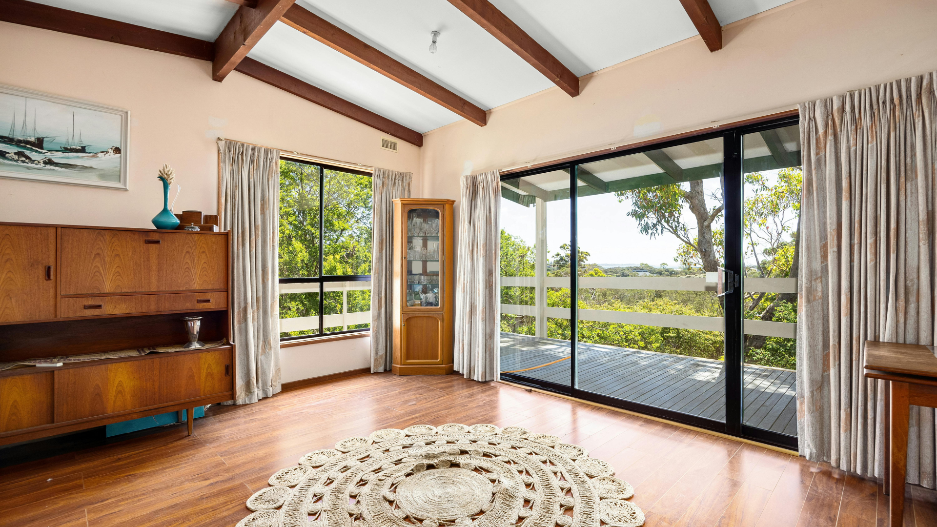 A living room with sliding glass doors and a rug on the floor.