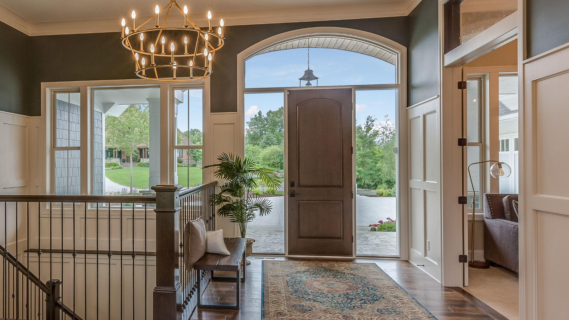 A large hallway in a house with a chandelier hanging from the ceiling.
