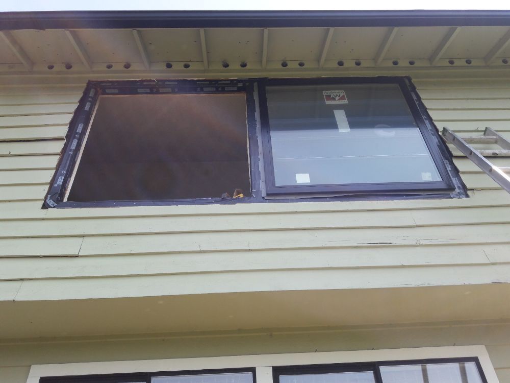 A window on the side of a house with a ladder attached to it