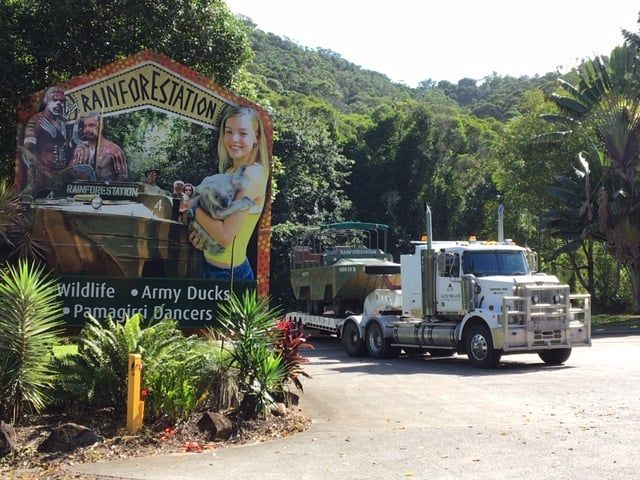 A Truck is Parked in Front of a Sign That Says Rainforestation — Kelly's Crane Hire in Mossman, QLD