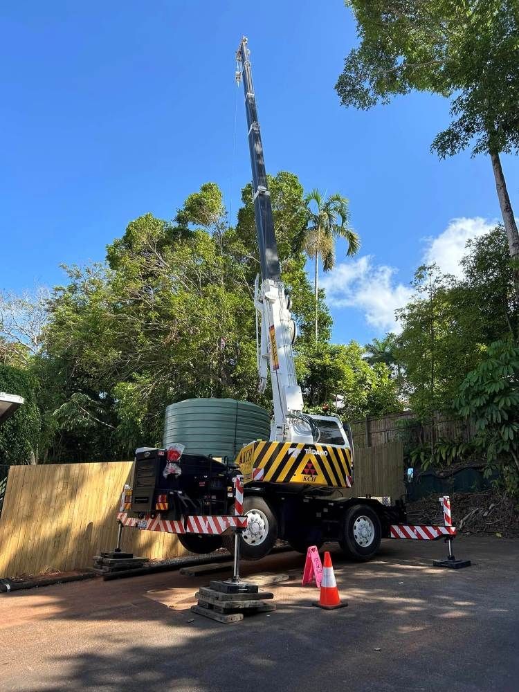 A Large Crane is Parked in Front of a House — Kelly's Crane Hire in Port Douglas, QLD