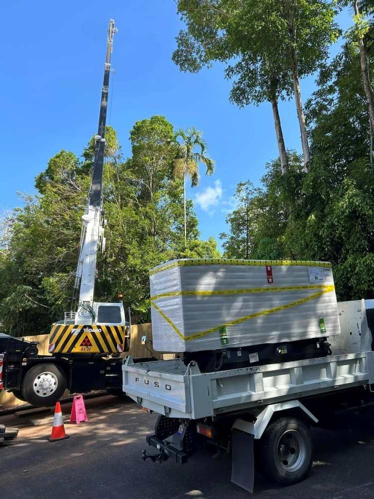 A Dump Truck With a Crane Attached to It is Parked in a Parking Lot — Kelly's Crane Hire in Mossman, QLD