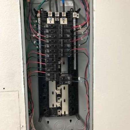 Electrical panel with various wires connected to circuit breakers.