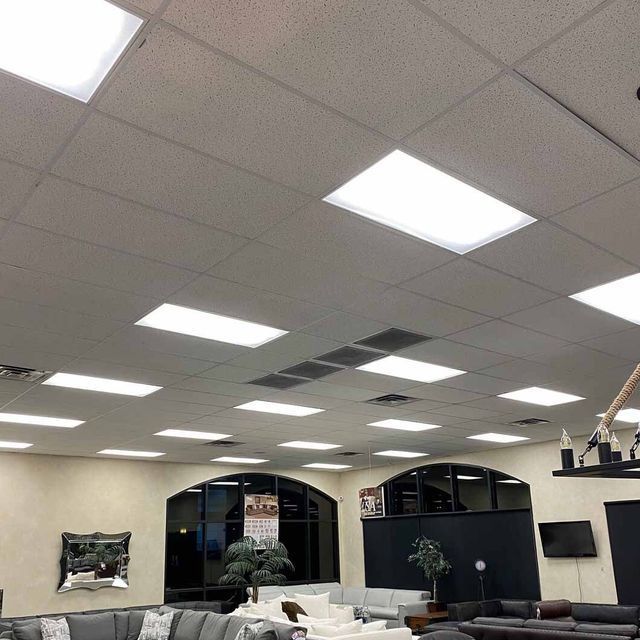 Interior of a furniture store with recessed lighting and neutral-colored walls. Displays sofas and decorative items.