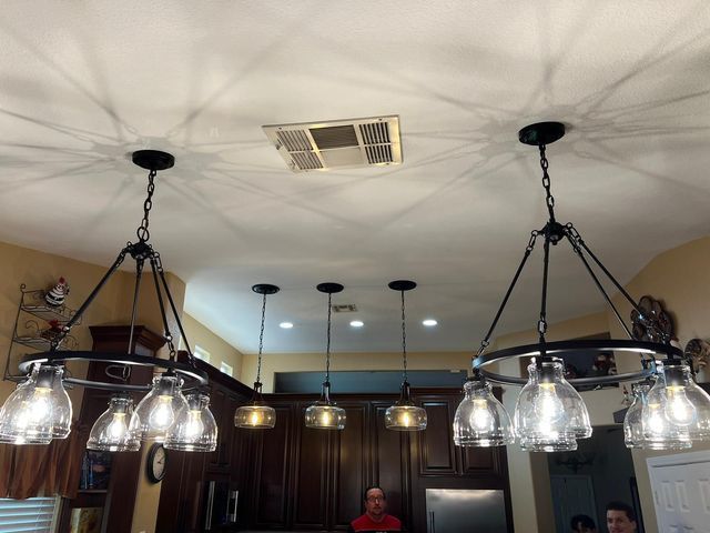 Two matching pendant lights over a kitchen island with several smaller lights behind them.