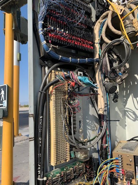 Open electrical cabinet with numerous wires, connectors, and circuit boards, likely for traffic signal control.