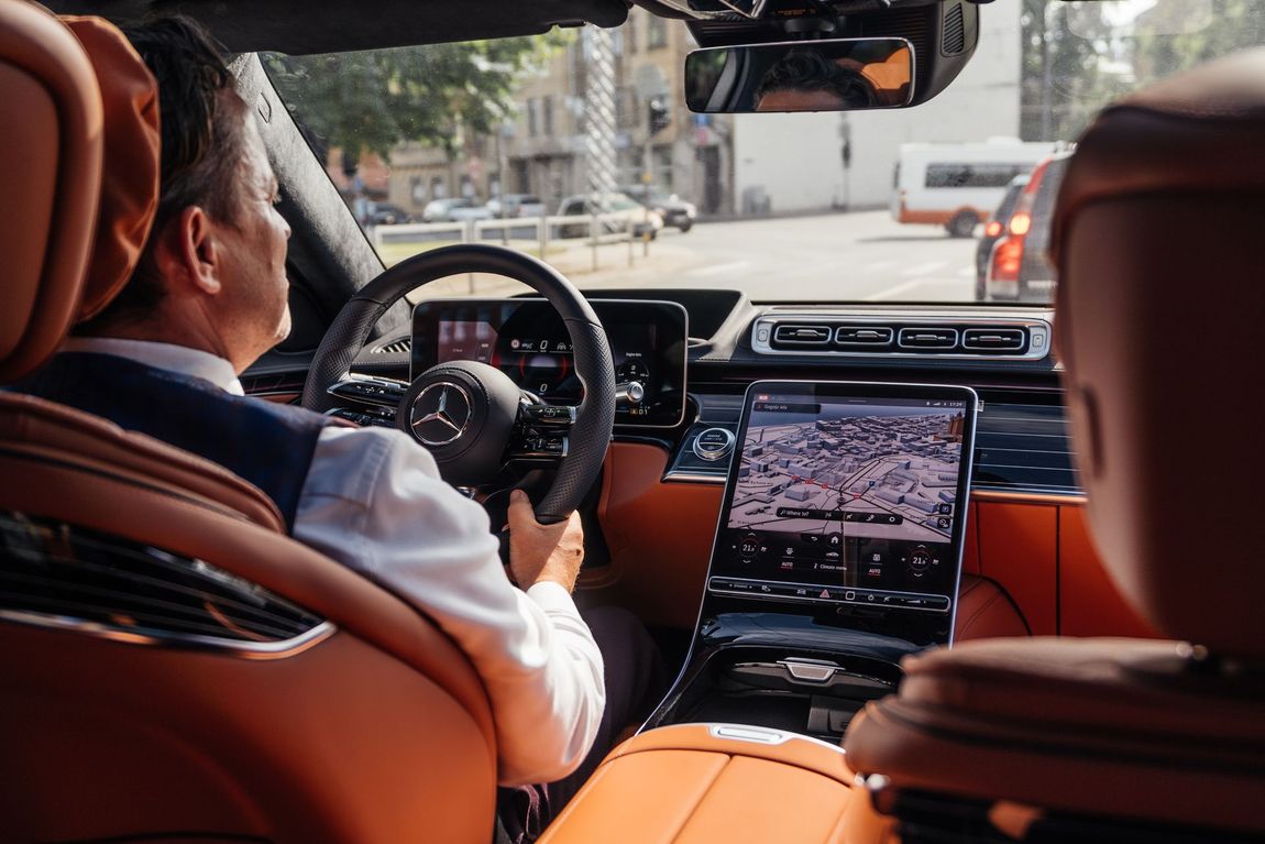 A man is sitting in the driver 's seat of a car.