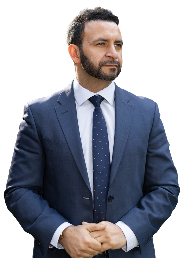 A man in a suit and tie is standing in front of a white background.