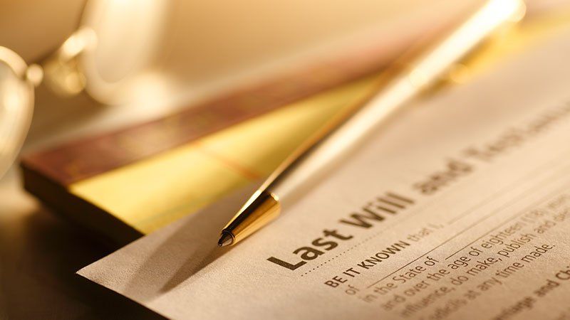 A pen is sitting on top of a last will and testament