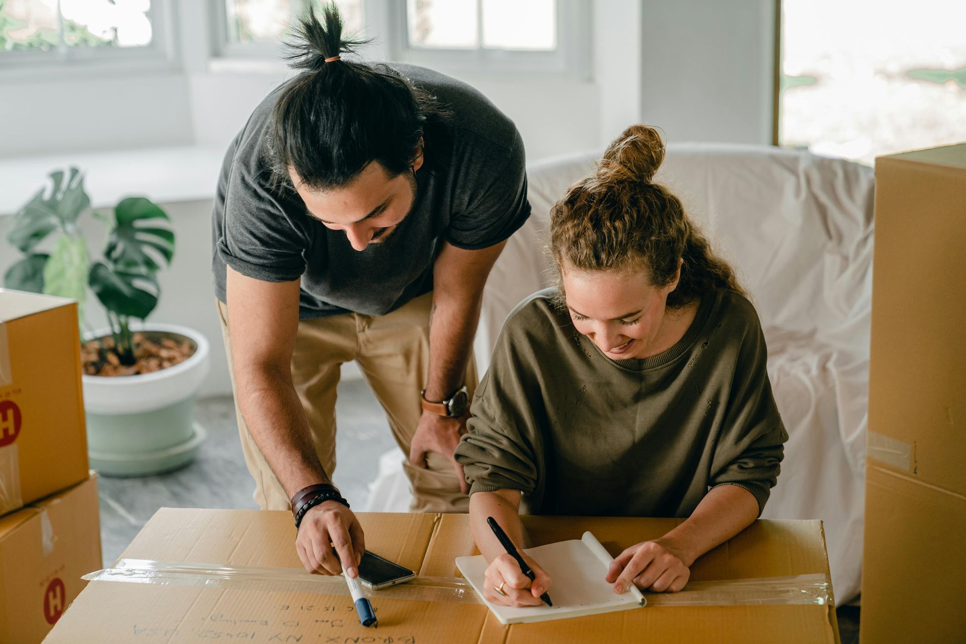 A man and a woman are sitting at a table with boxes.