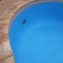 a close up of a blue swimming pool on a patio .
