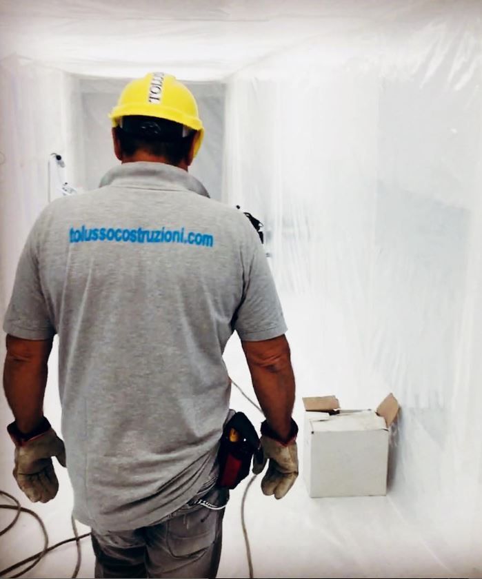 Dipendente della Tolusso Costruzioni cammina di spalle in un corridoio 