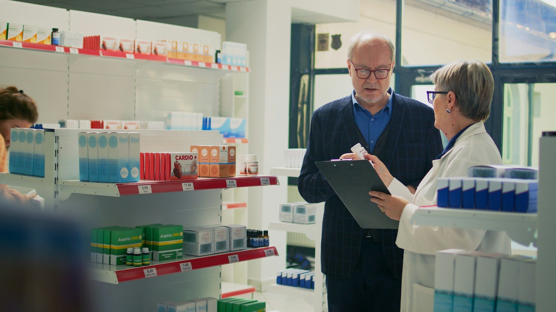 Pharmacist in white coat assisting a senior man in a pharmacy, reviewing a clipboard.