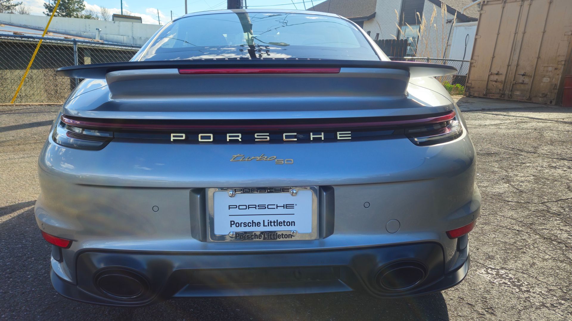 Silver Porsche 911 Turbo with black accents; rear view; outdoors, daytime.