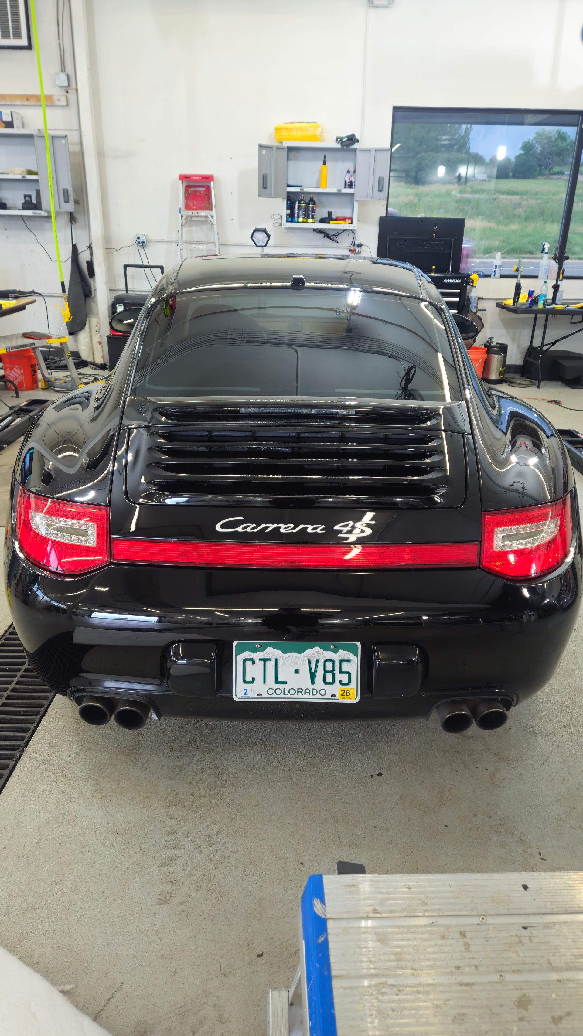 Black Porsche Carrera 4S coupe, rear view. In a workshop, with license plate CTL-V85.