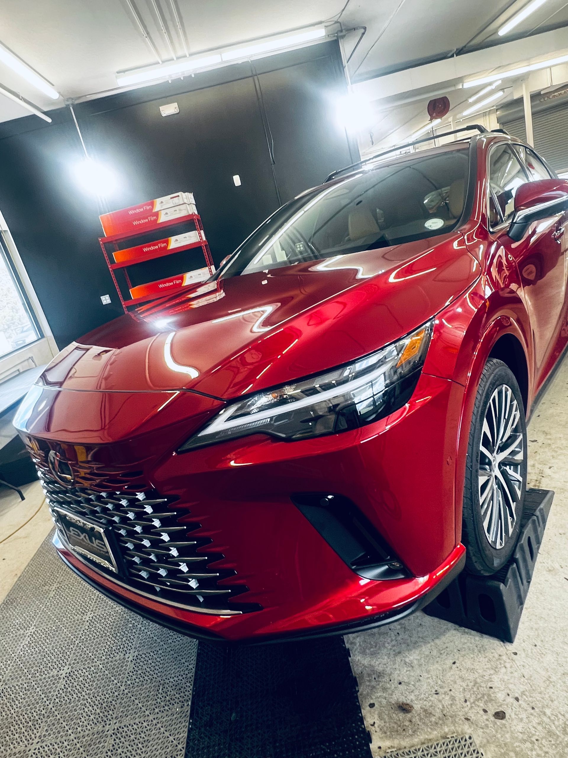 Red Lexus SUV parked indoors, illuminated.