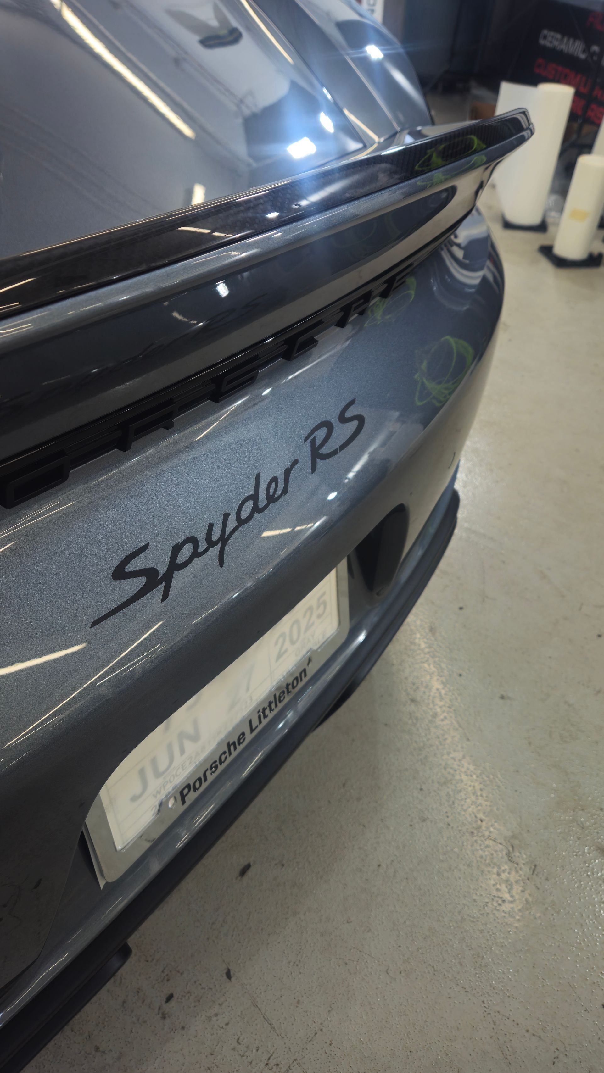 Close-up of a gray Porsche Spyder RS with a black spoiler. The 
