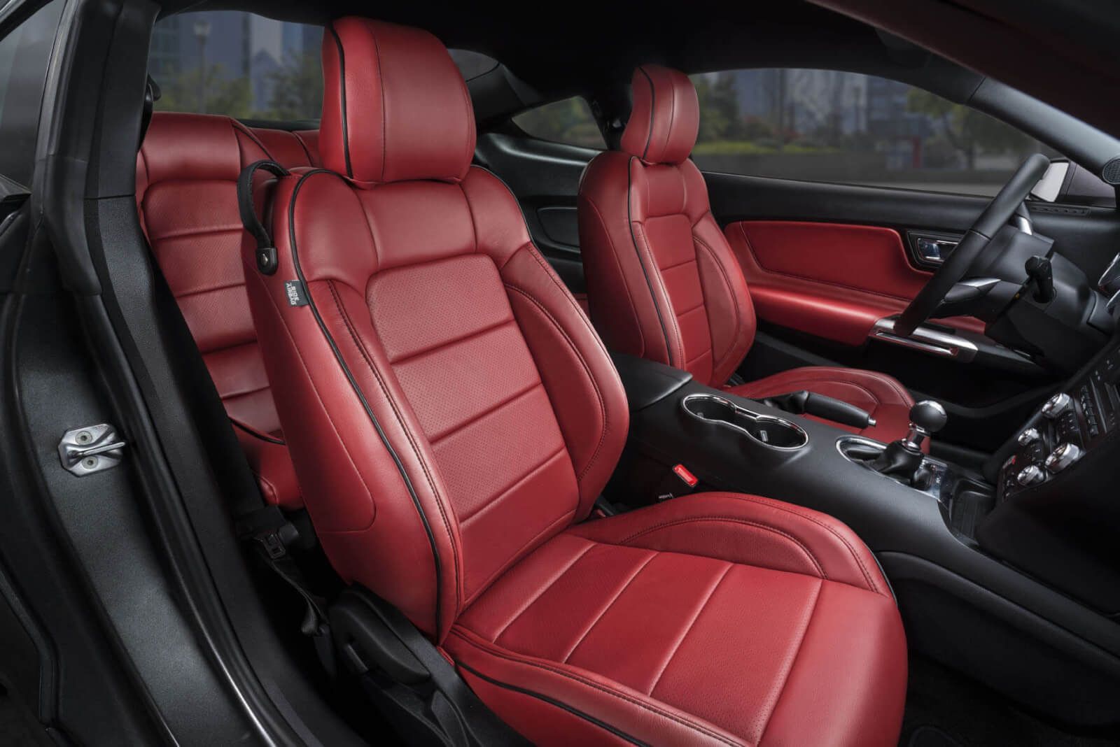 Red leather car interior with bucket seats and a black dashboard.